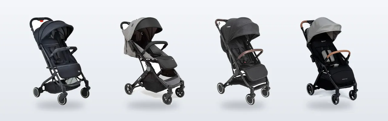 Quatro carrinhos de bebê de modelos diferentes enfileirados lado a lado em uma sala